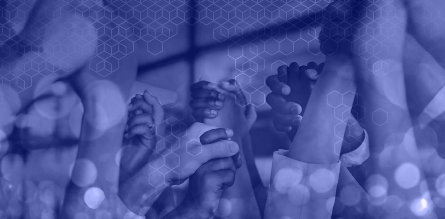 Groep statushouders en begeleiders staan samen in een kring, handen ineen